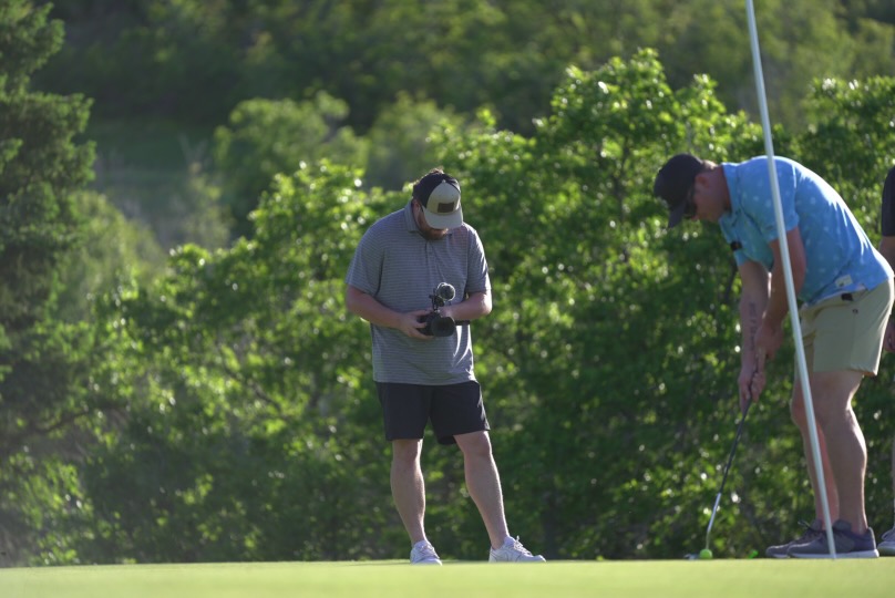 Birdie Film Co. videographer filming a golfer putting on the green