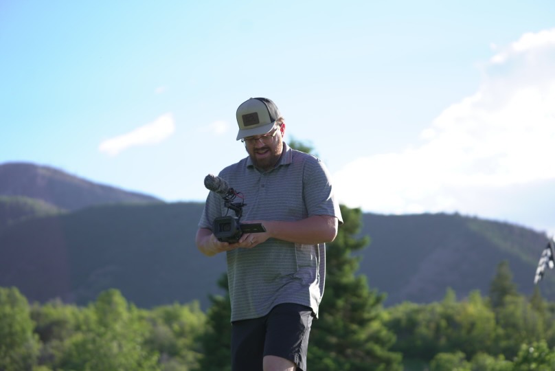 Birdie Film Co. videographer reviewing footage on the golf course
